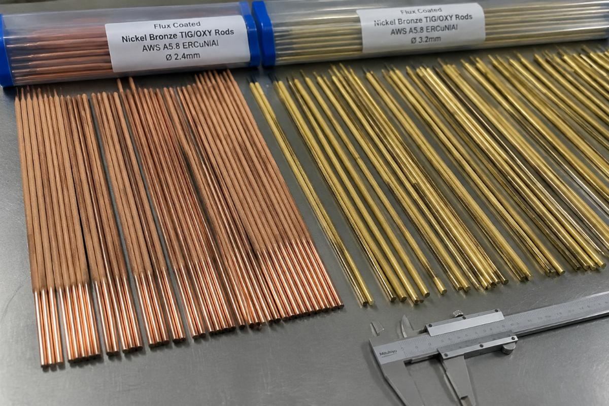 Full size flux coated nickel bronze TIG/OXY rods laid out for industrial quality inspection